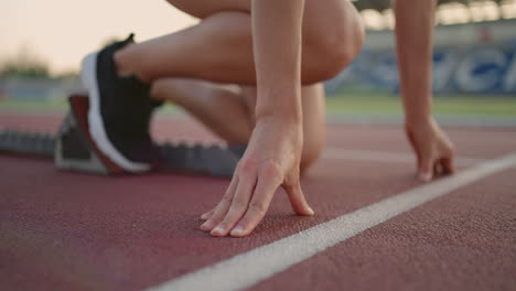 One-Young-woman-runner-in-the-sunlight-at-the-stadium-arena-getting-ready-for-the-run-gets-into-running-shoes-and-runs-sprint-from-the-start-line-in-slow-motion